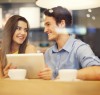 Flirting couple in cafe using digital tablet
